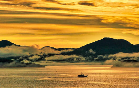 Bateau sur l’Inside Passage au coucher du soleil en Colombie-Britannique