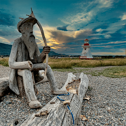 Personnage sculpture de bois avec le petit phare de Carleton-sur-Mer