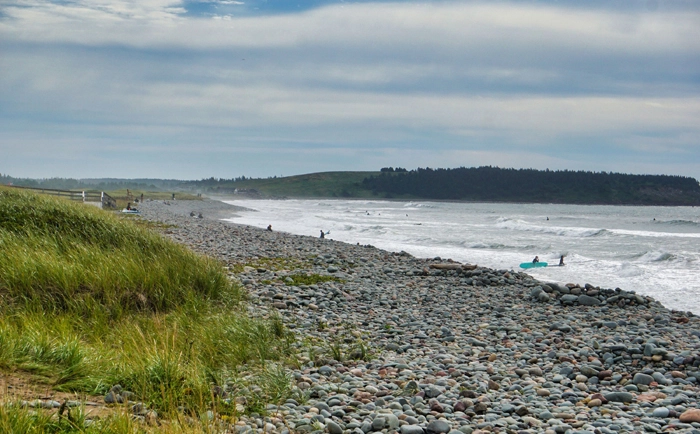 Surfeurs sur la plage de galets de Lawrencetown Beach